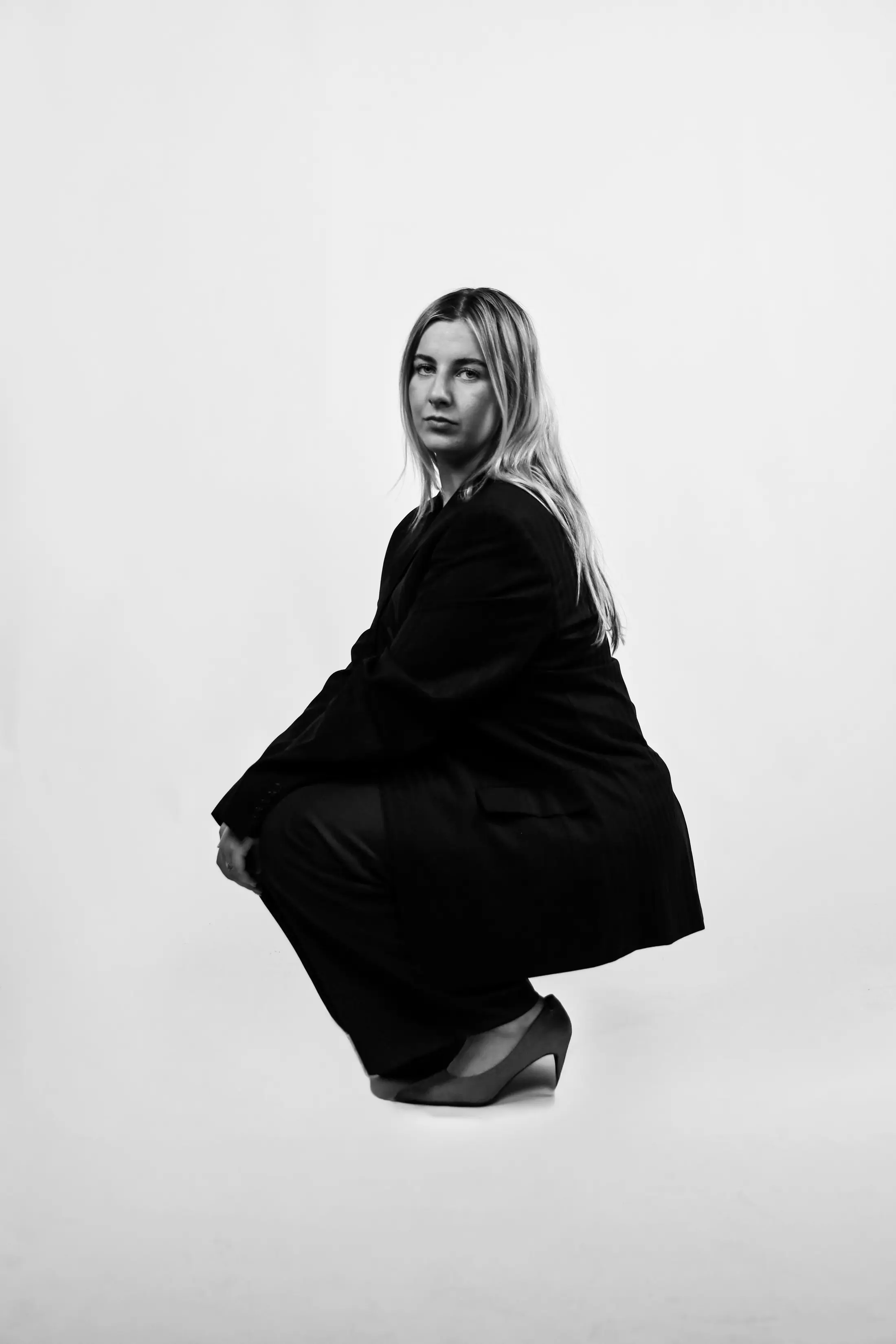 Model zittend in zwart pak