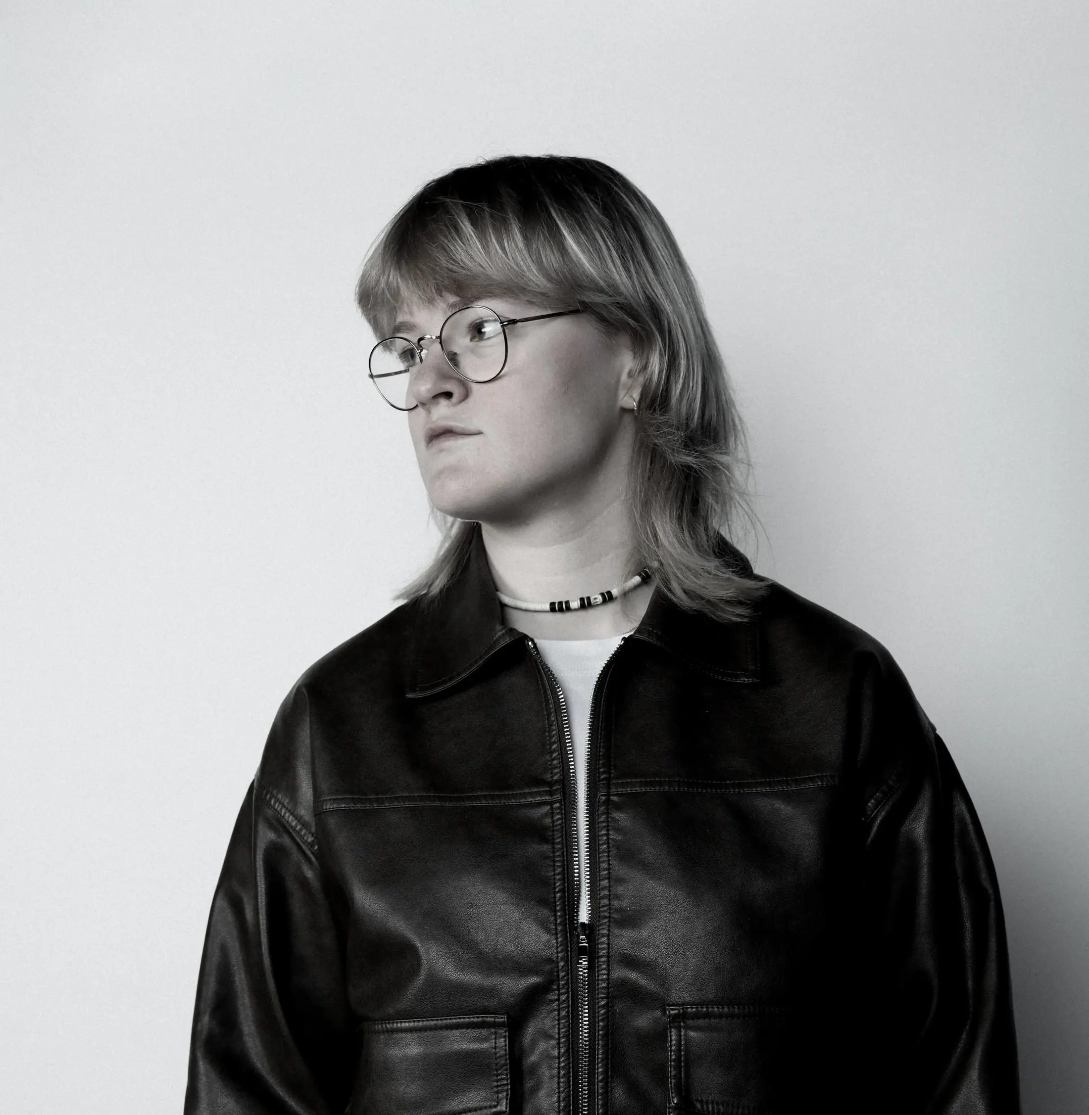 Zwart-witportret met bril en leren jas