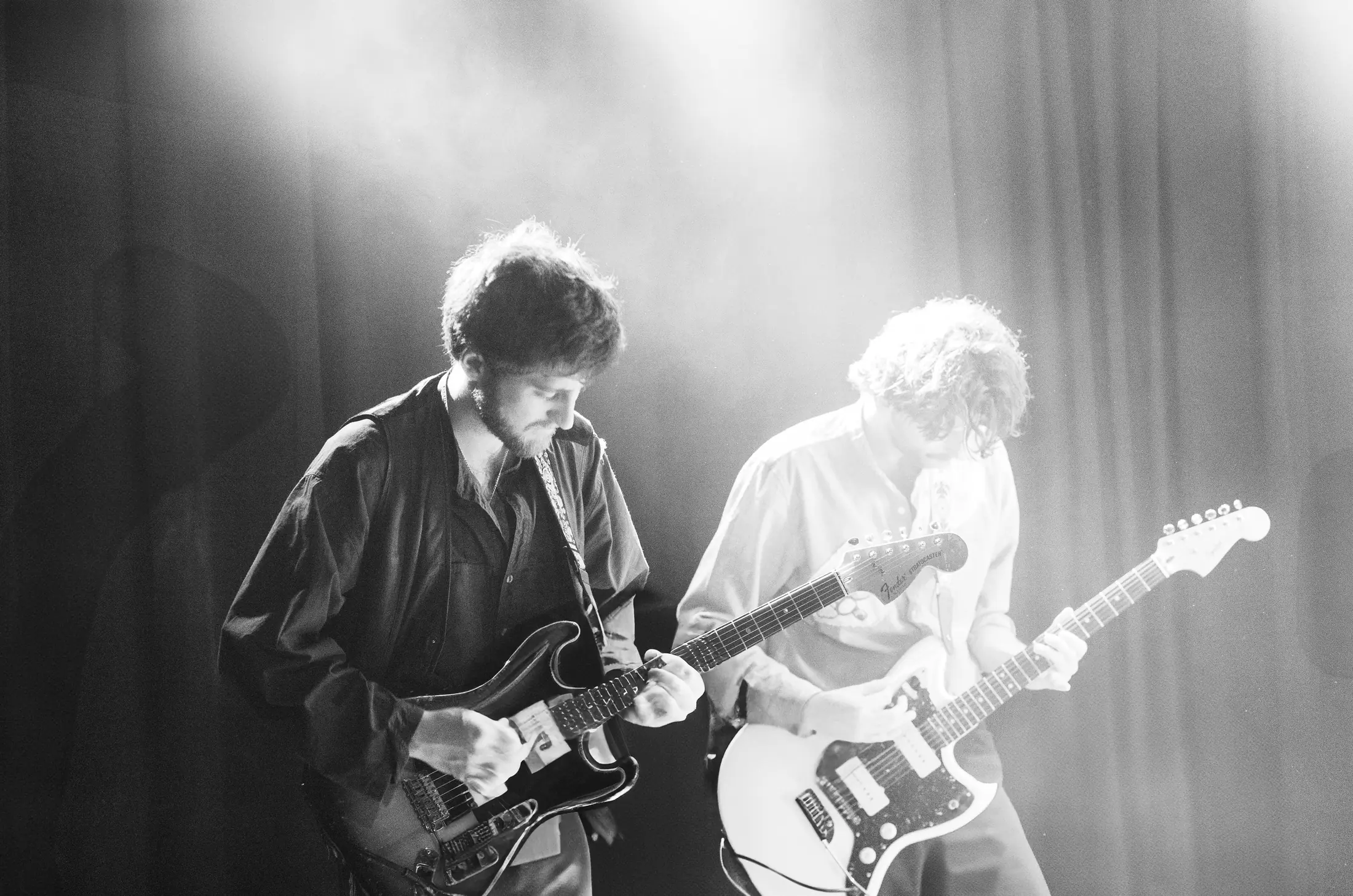 Zanger met gitaar op podium
